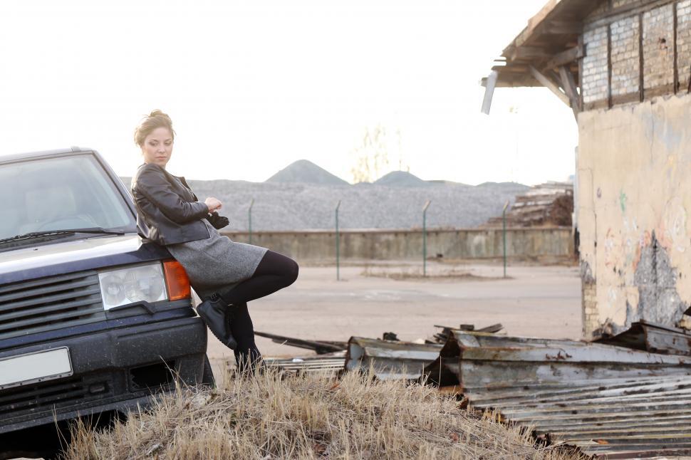 Free Image of Cool girl leaning on the car 