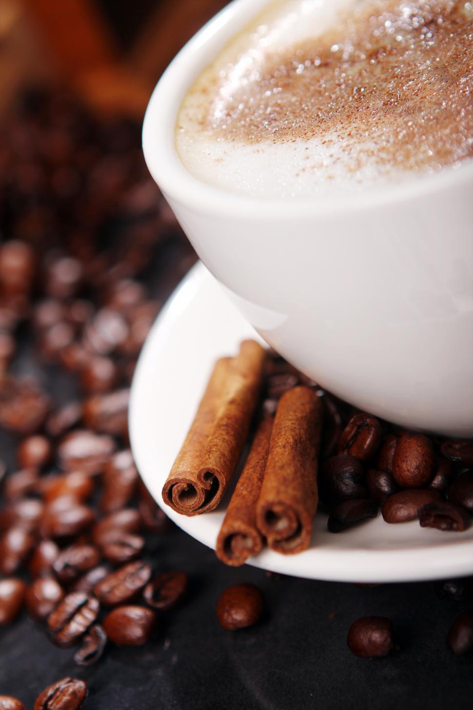 Free Image of Coffee cup on the table with coffee beans around 