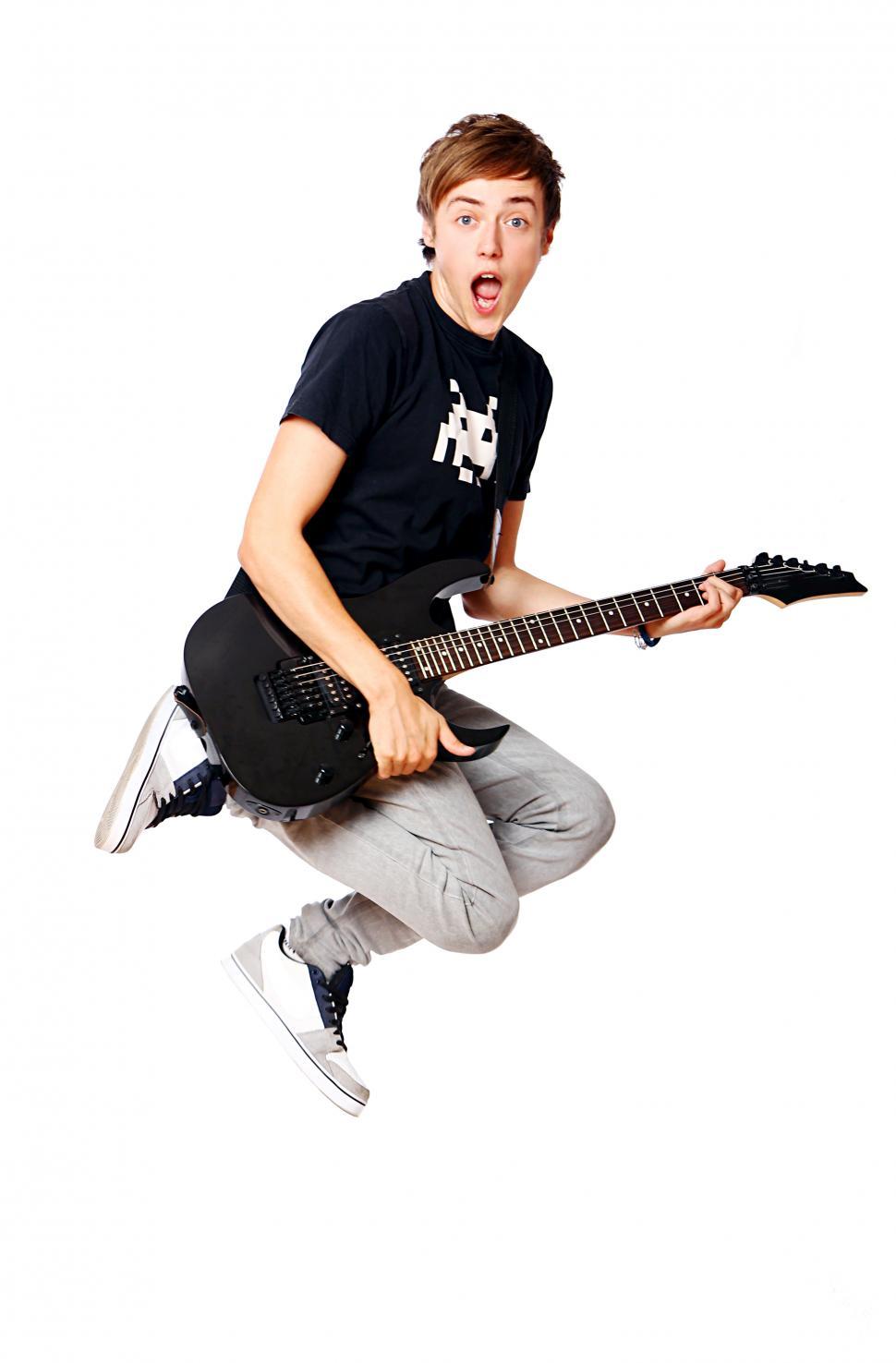 Free Image of Young teenager jumping with guitar 