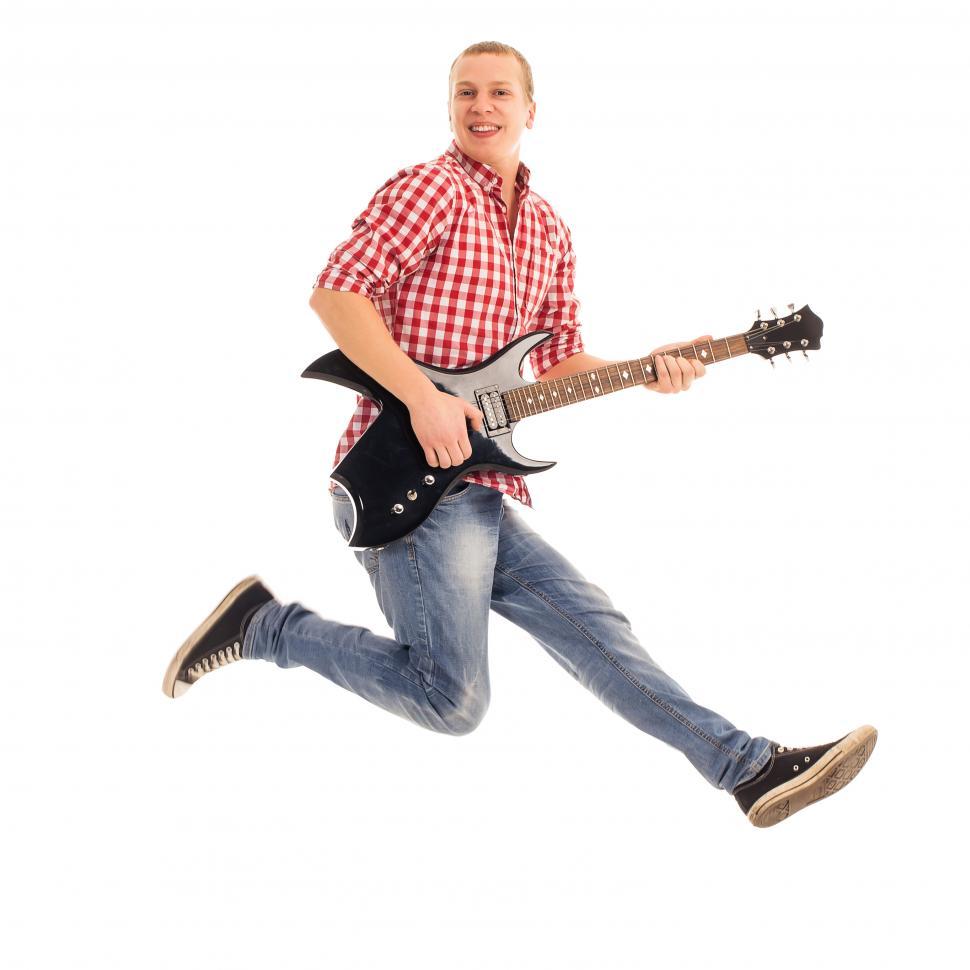 Free Image of Young musician jumping with a guitar 