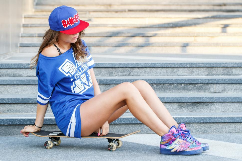 Free Image of Girl sitting on a skateboard 