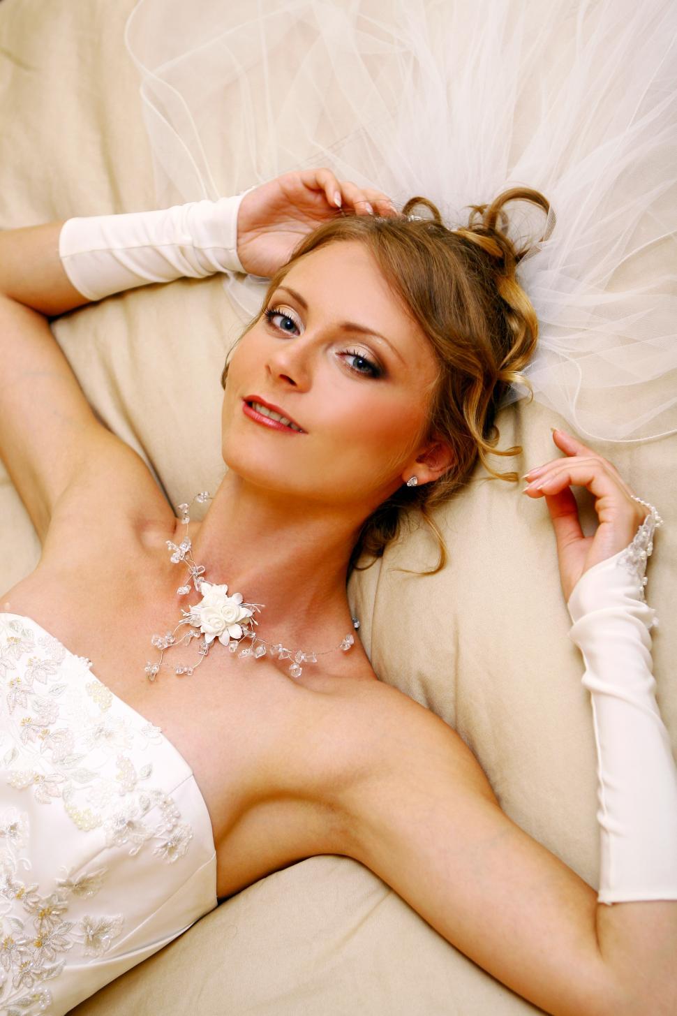 Free Image of beautiful adult woman laying down in wedding dress 