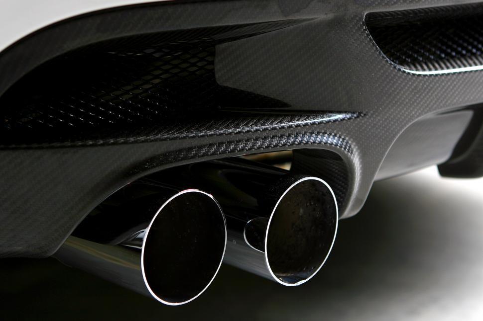 Free Image of tailpipe of new white car on black background 