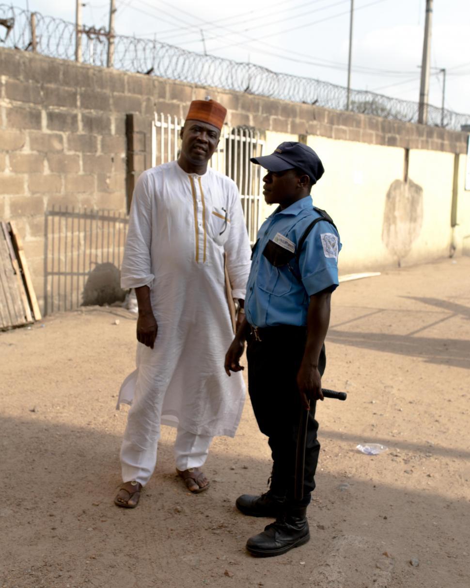 Free Image of Two nigerian men standing outside of the building 