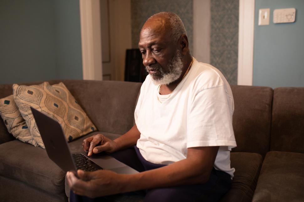 Download Free Stock Photo of Older Man with white beard using laptop at home 