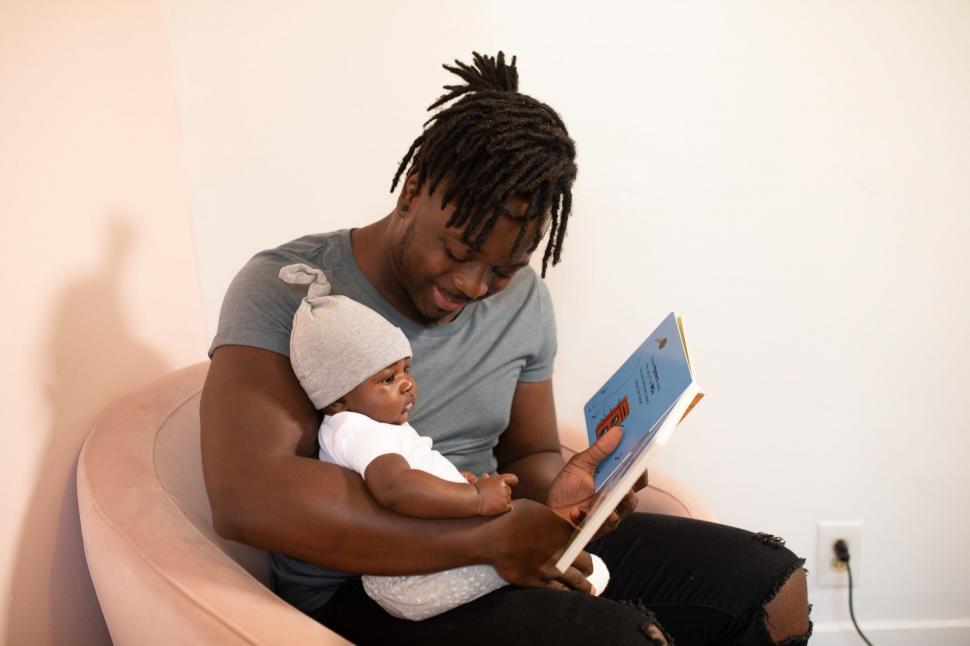 Free Image of Young Father and Little Baby With Book 