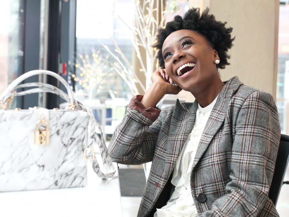 Free Image of Stylish young woman in tweed blazer laughing in a restaurant 