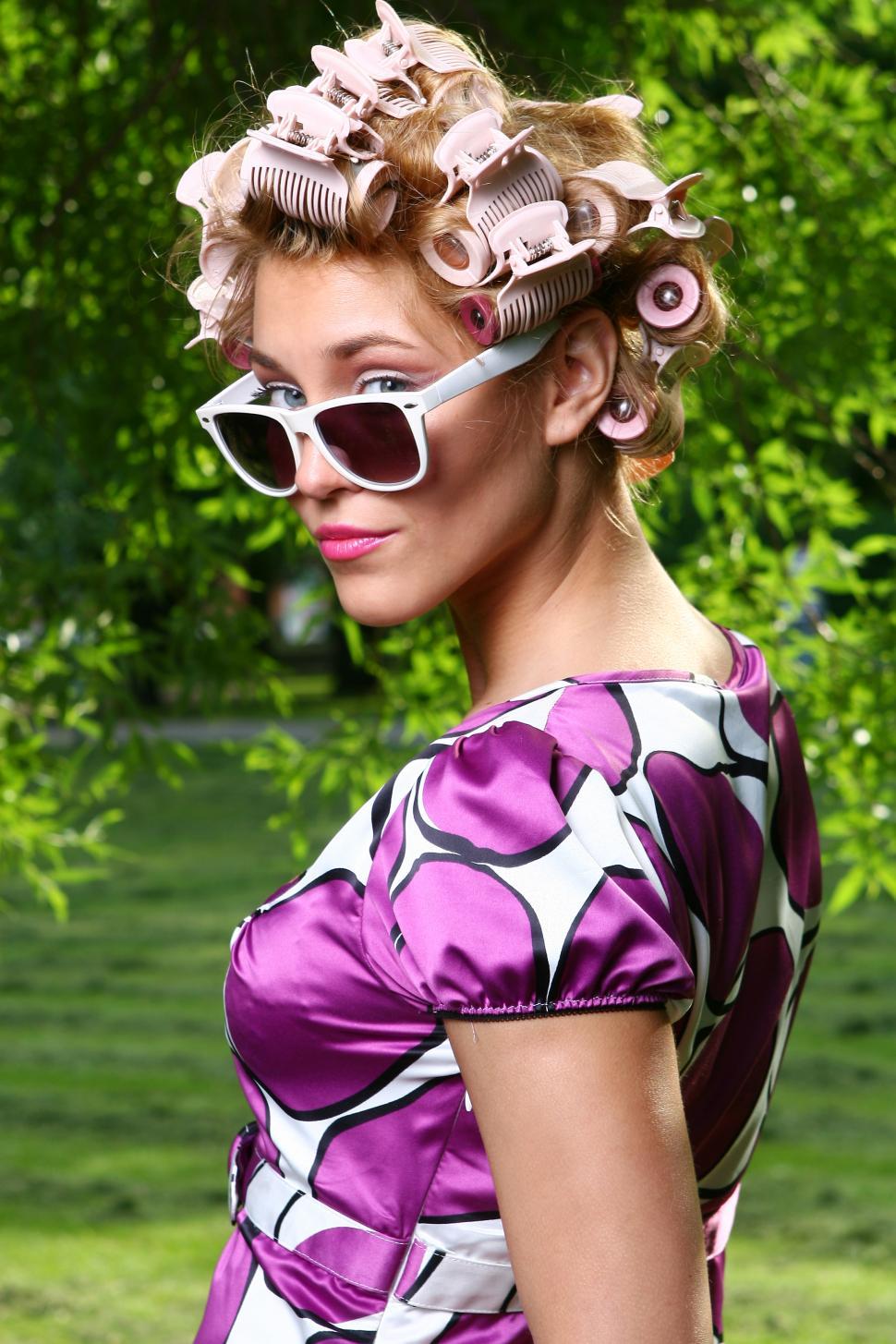 Free Image of coy young woman looking over sunglasses 