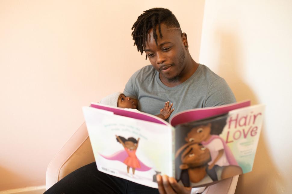Free Image of Young Father Reading Book For Little Baby 