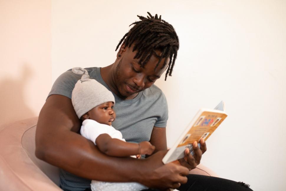 Free Image of Young Father And Little Baby With Book 