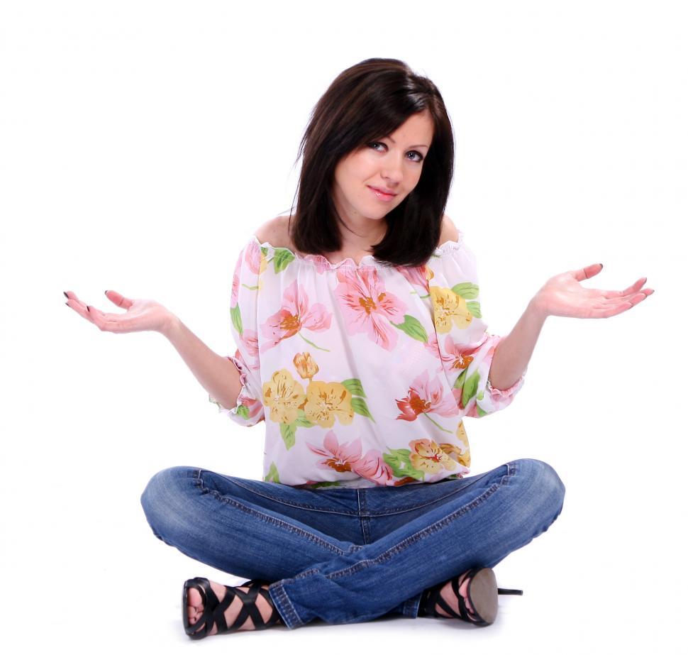 Free Image of Seated woman shrugging in confusion 