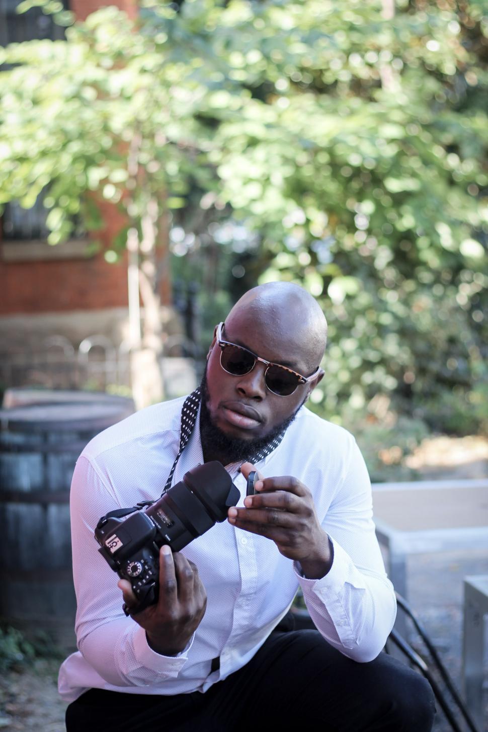 Free Image of Young Bald Man in Sunglasses With Camera 