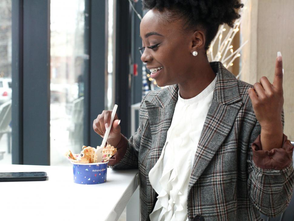 Free Image of Young business woman in tweed blazer eating ice cream 