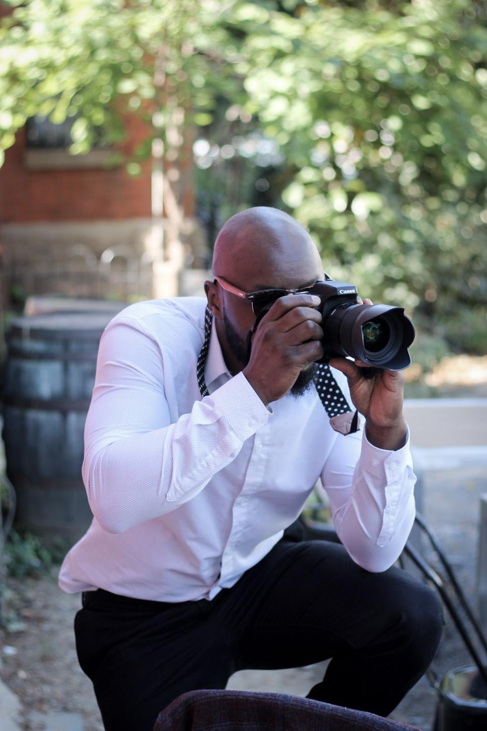 Free Image of Young Bald Man with DSLR camera 