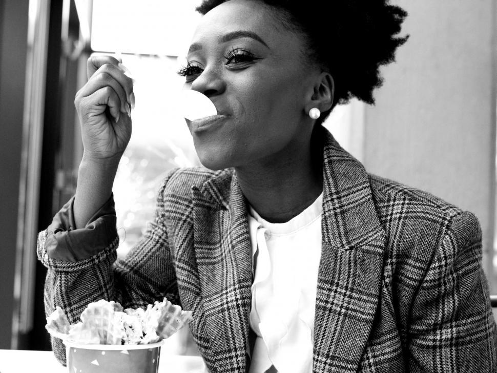 Free Image of Young business woman in tweed blazer eating ice cream - B&W 
