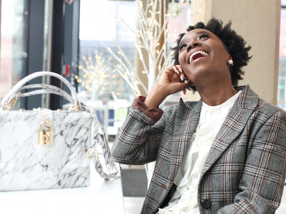 Free Image of Young business woman in pearl earrings laughing in a restaurant 