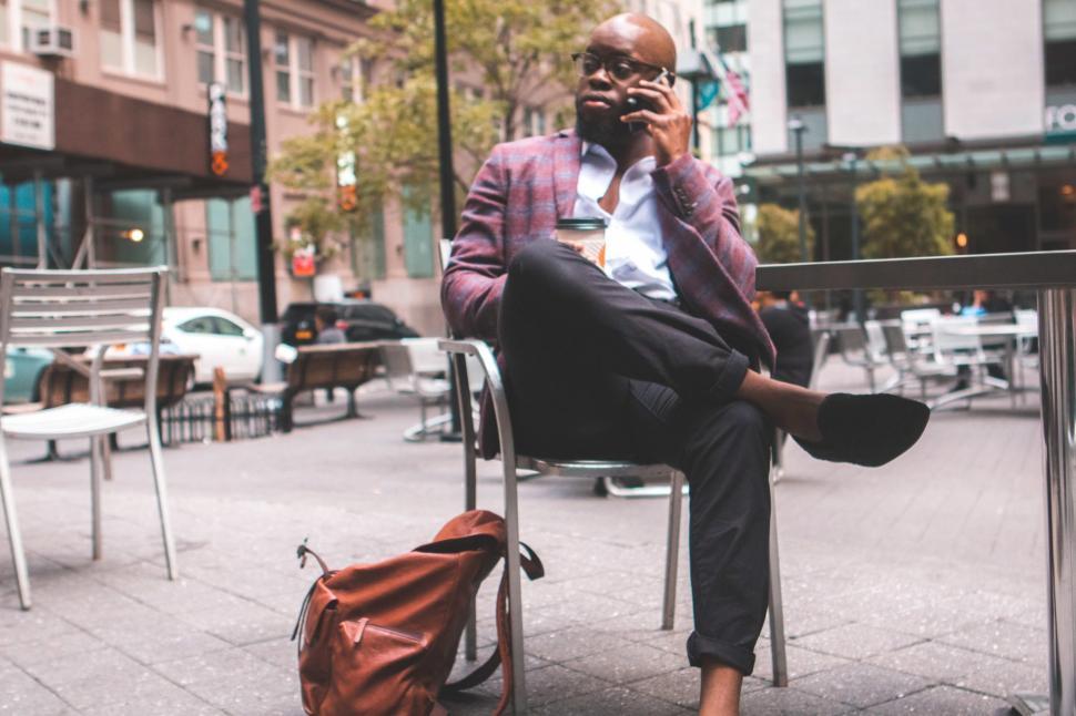 Free Image of Young Businessman in spectacles talking on mobile phone at outdo 