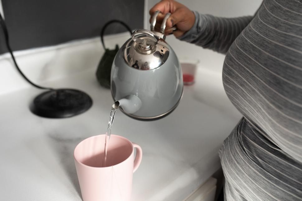 Free Image of Unrecognizable Woman Hand and Kettle With Tea Cup 