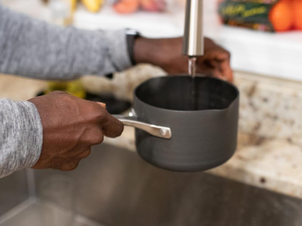Free Image of Filling water in pot at the kitchen sink 