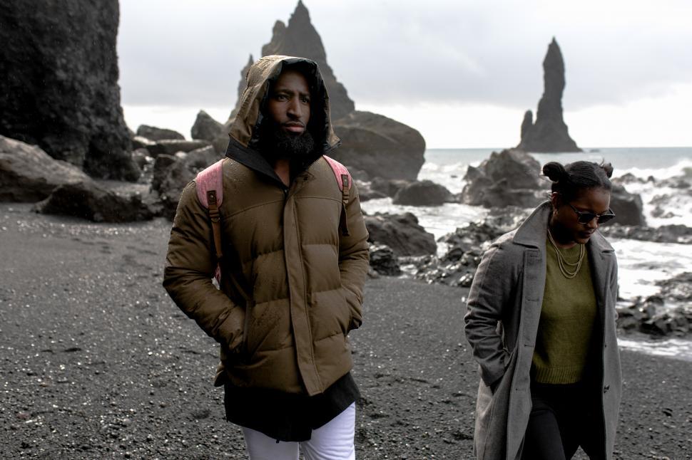 Free Image of Young Couple in Winter Clothing Walking at seashore 