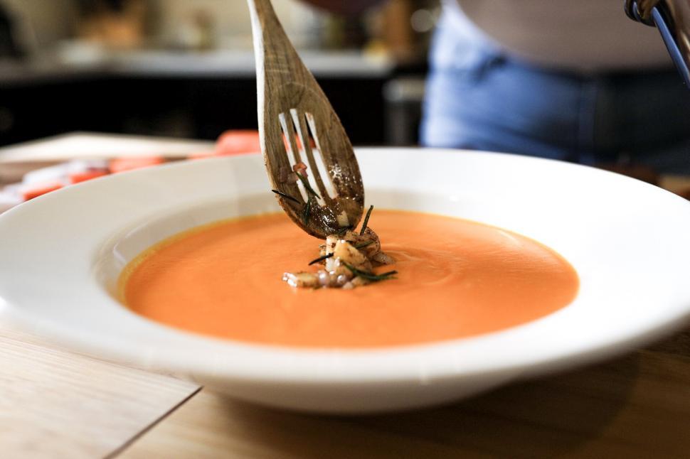 Free Image of Garnishing Carrot soup on wooden table 