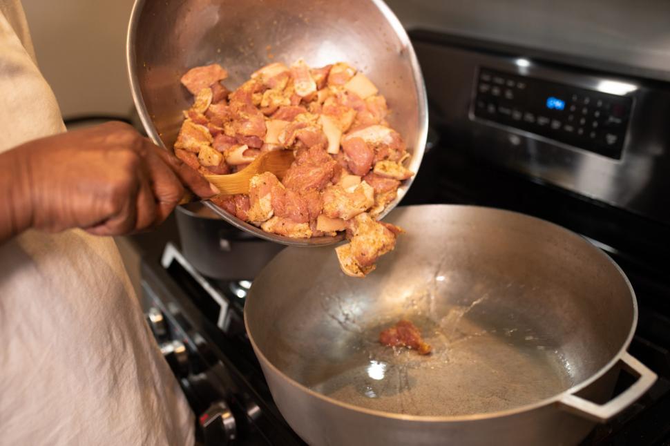 Free Image of Pouring meat pieces into cooking pot 