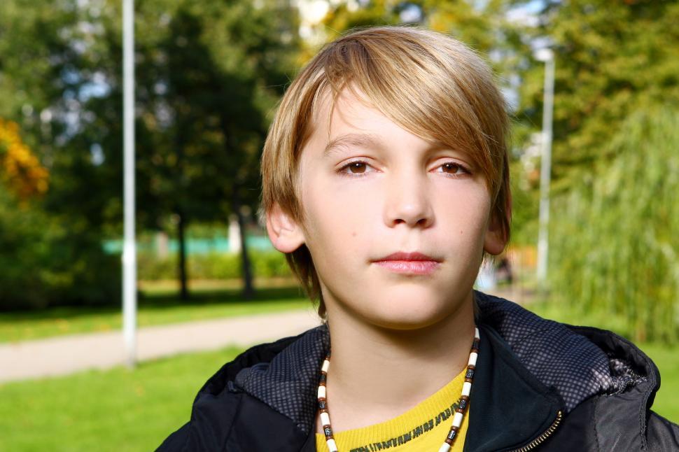 Free Image of Attractive blonde boy posing in park 
