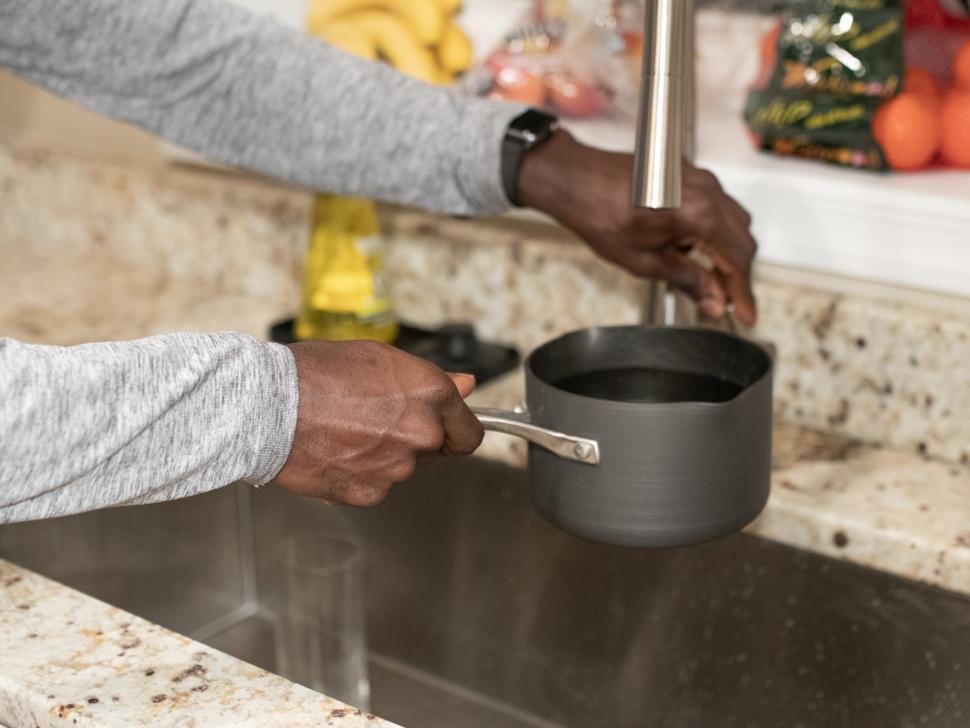 Free Image of Putting water in pot at the kitchen sink 