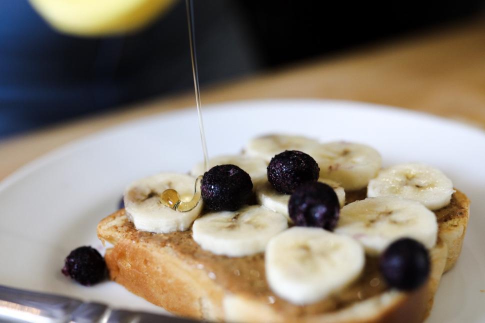 Free Image of Pouring honey on bread covered in fruit - breakfast 