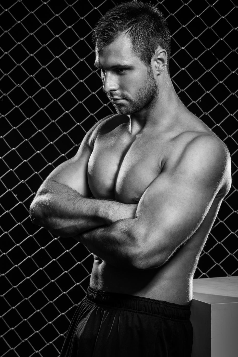 Free Image of Fitness. Shirtless muscular man standing with arms crossed. Black and white. 