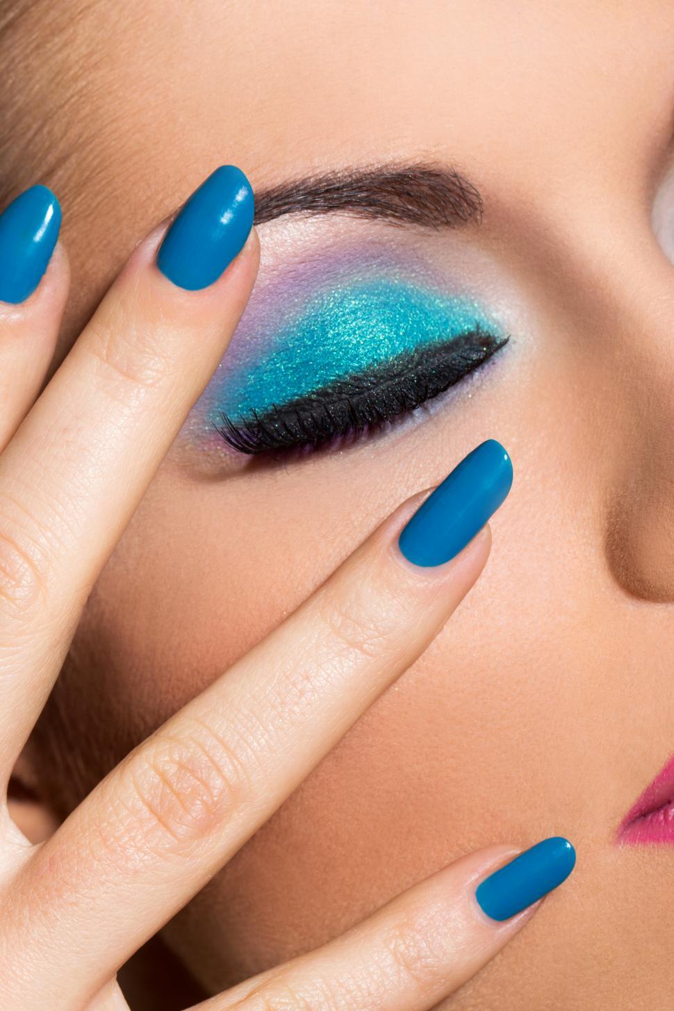 Free Image of Woman with colorful makeup and polished nails, eyes closed 