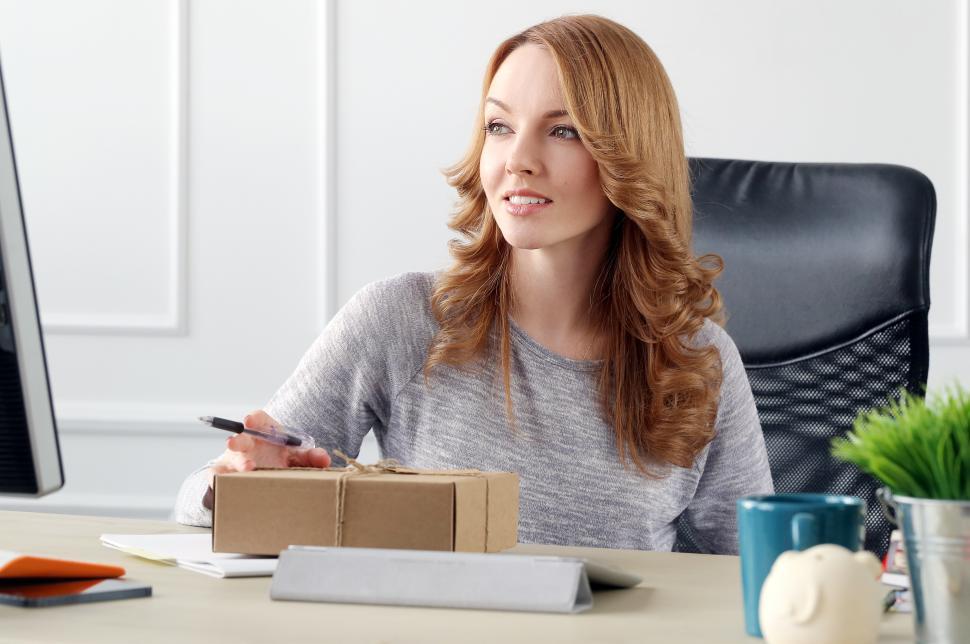 Free Image of Lifestyle. Woman at desk with package 