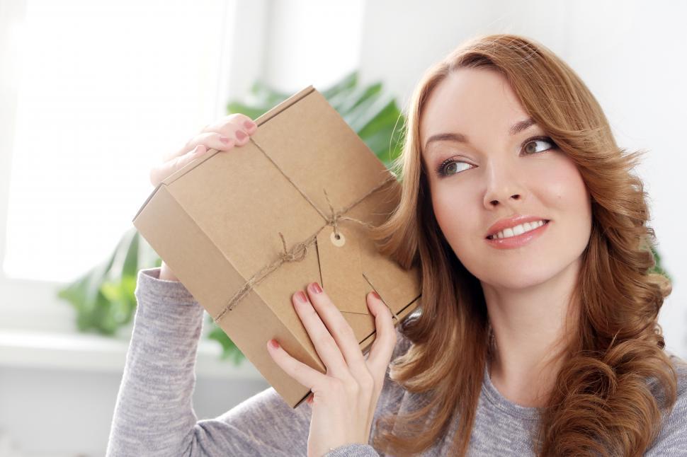 Free Image of Lifestyle. Woman wondering what a package holds 