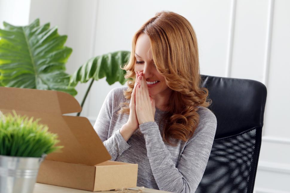 Free Image of Lifestyle. Woman delighted after opening a box 