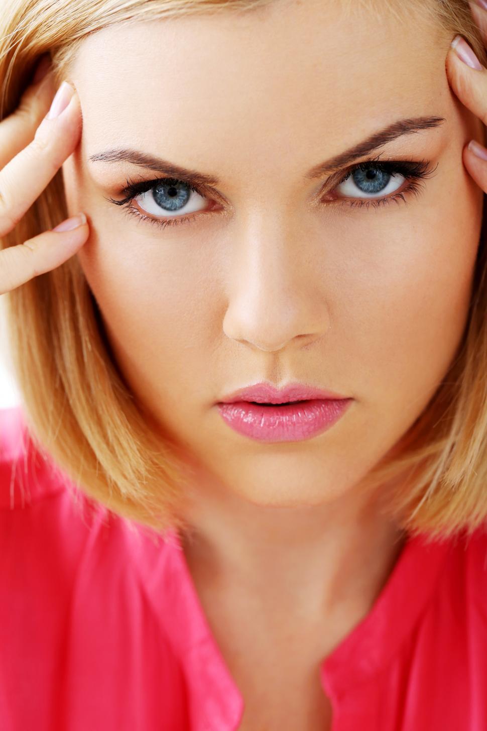Free Image of Woman with blue eyes close up, looking stressed 