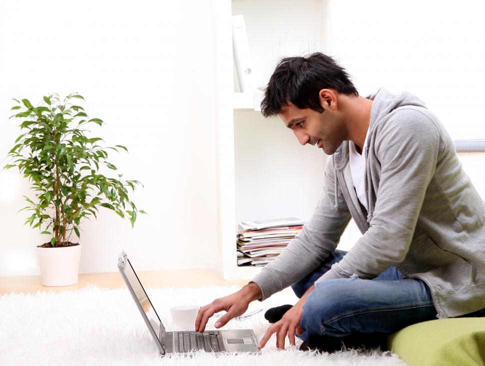 Free Image of young man reading from a laptop at home 