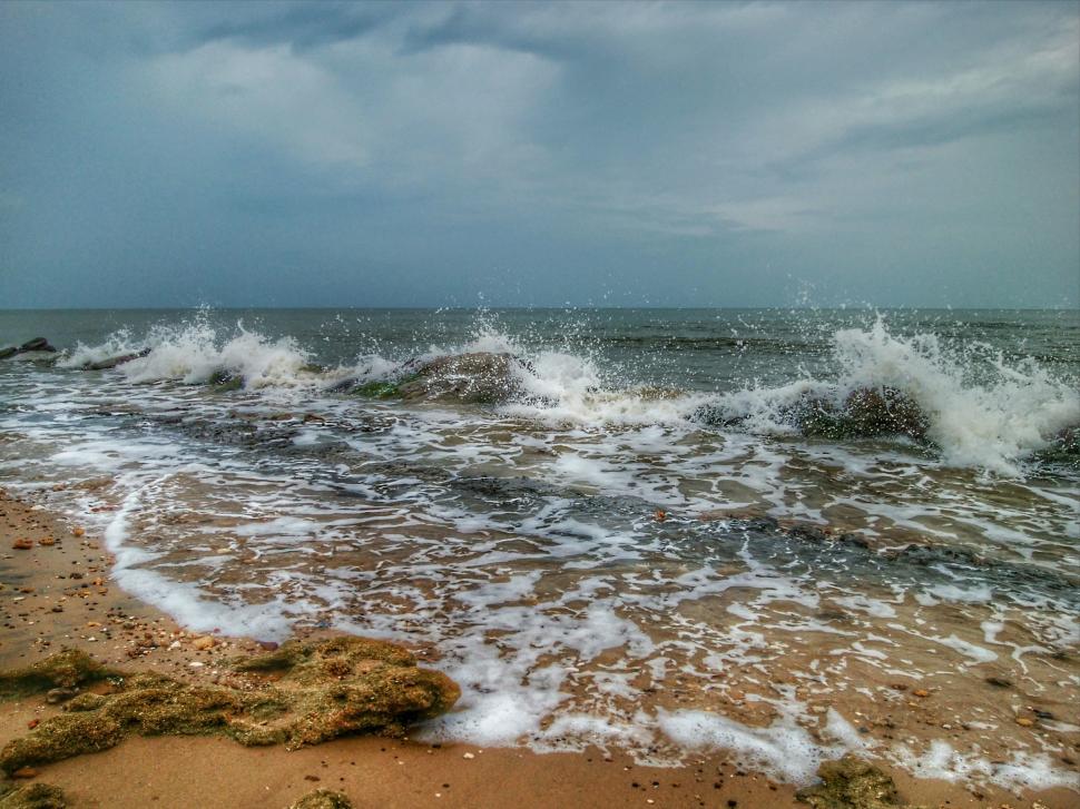 Free Image of Sea waves crashing on rocks and cloudy sky  