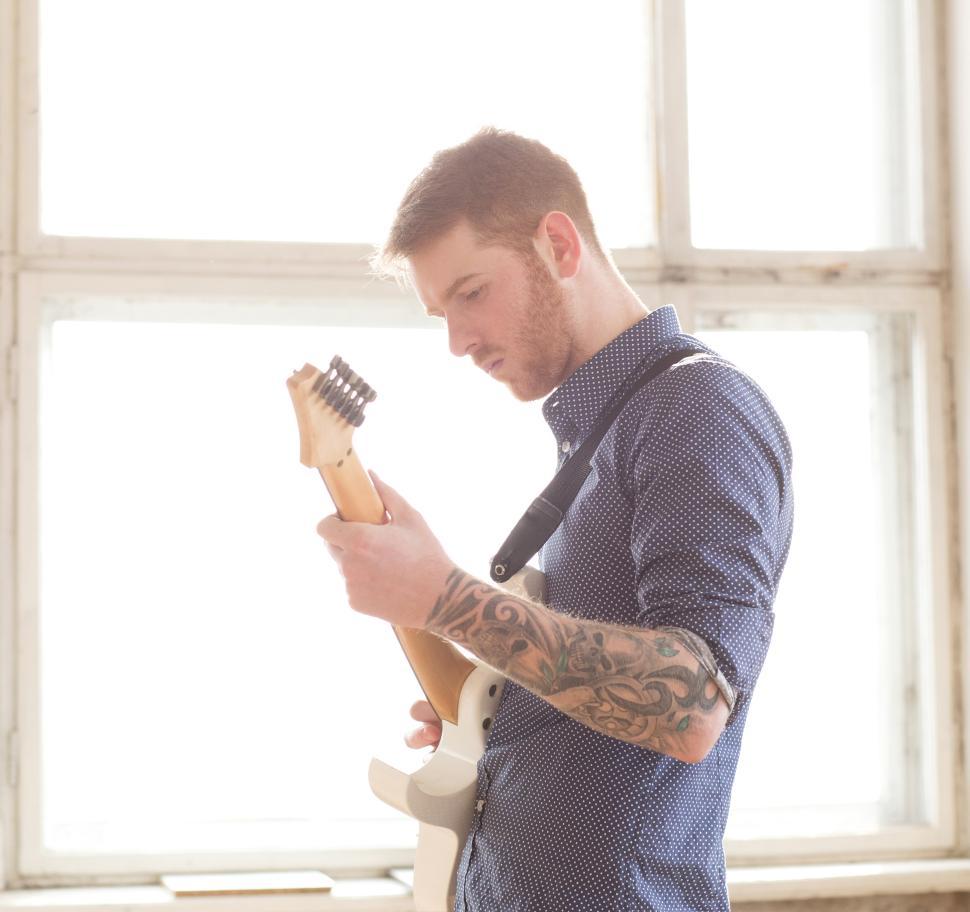 Free Image of Man standing and playing guitar 