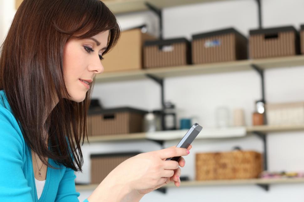 Free Image of Young woman with phone in home office 