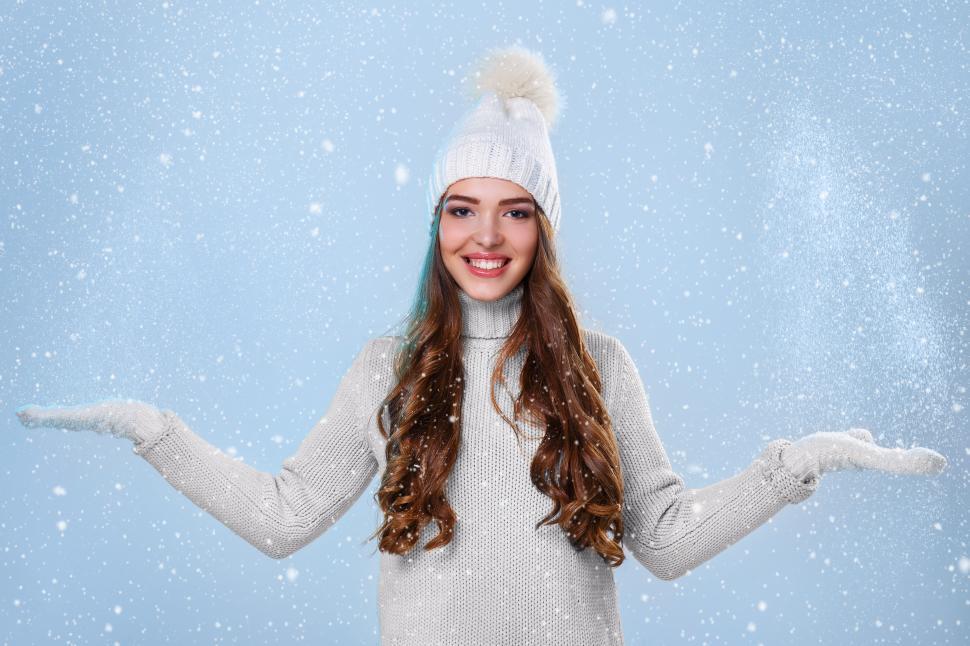Free Image of Woman in snowfall, wearing white sweater 