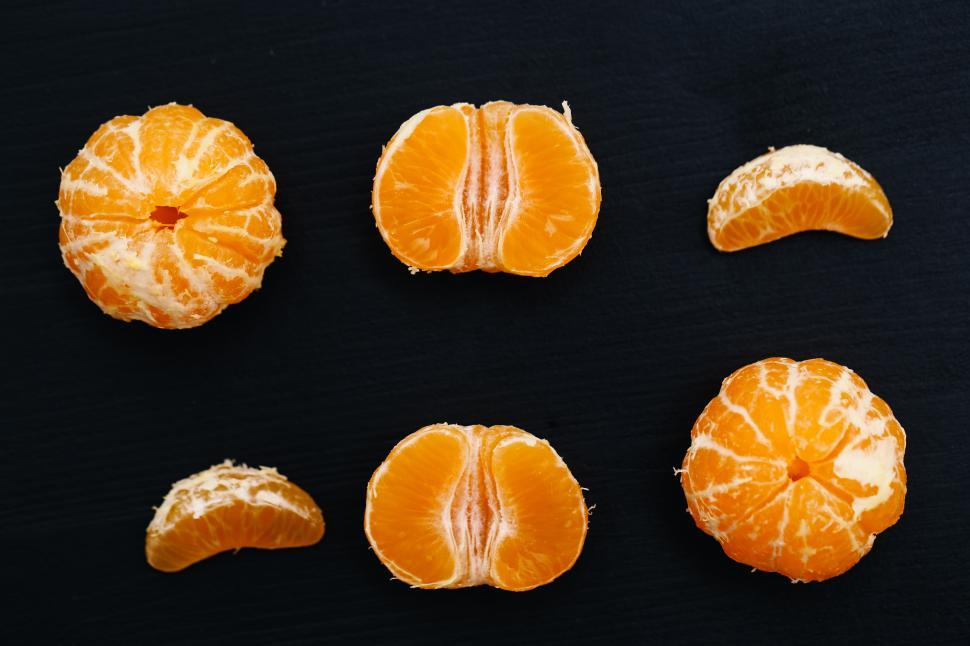 Free Image of Mandarins on the table in various pieces, whole, half, quarter 
