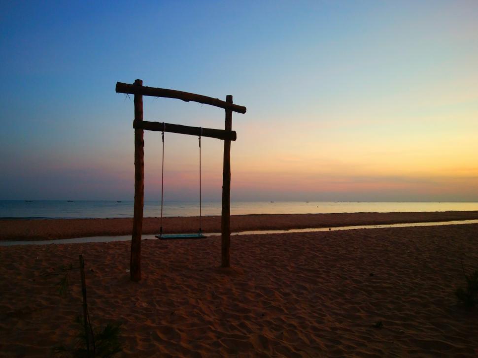 Free Image of Wooden swing on the beach at dawn  