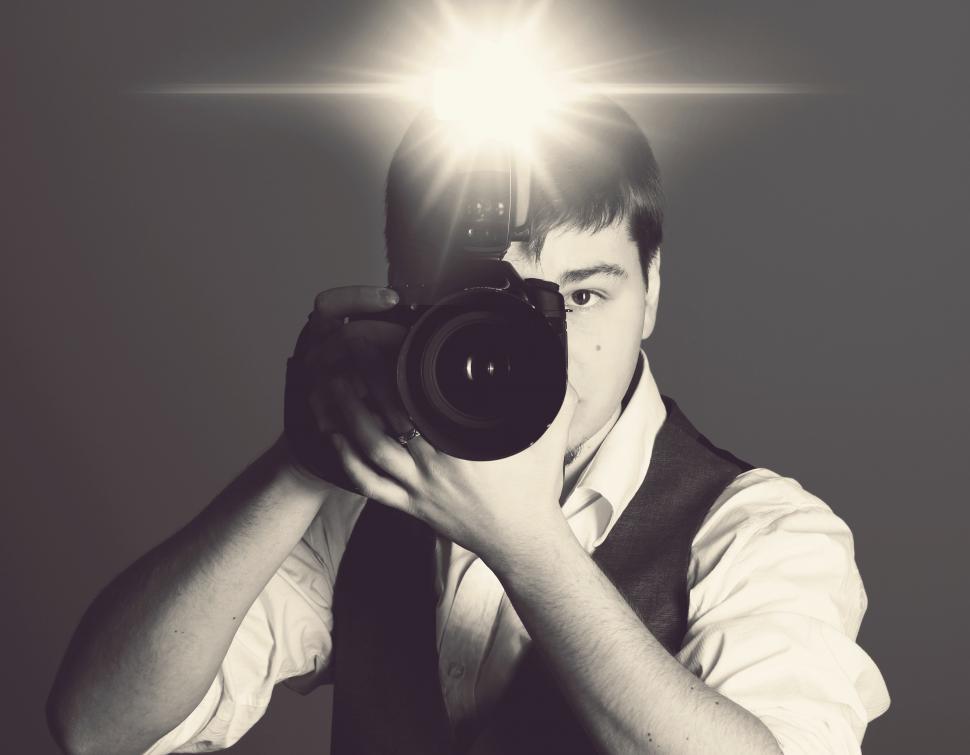 Free Image of Photographer with camera, flash firing 