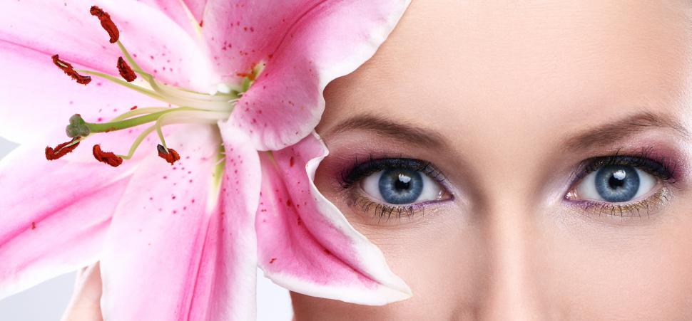 Free Image of Crop of a beautiful woman with single pink lily flower 