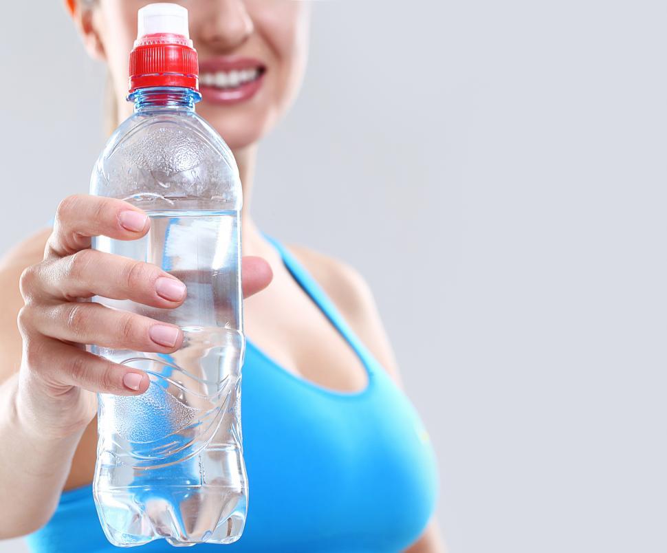 Free Image of Woman holding a bottle of water after workout 