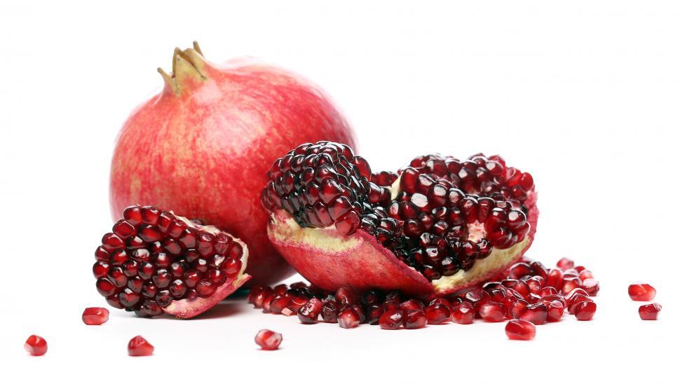 Free Image of Ripe pomegranates and seeds on white background 