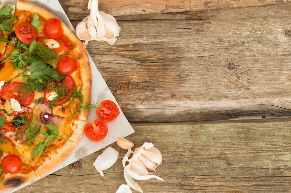 Free Image of Delicious pizza on wooden table with copyspace 