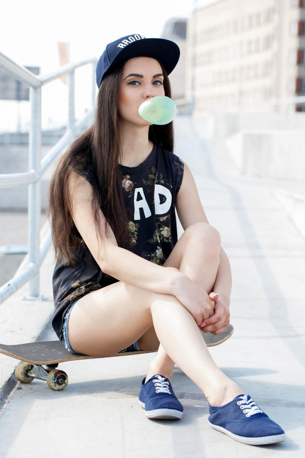 Free Image of Alternative girl with bubblegum and skateboard 