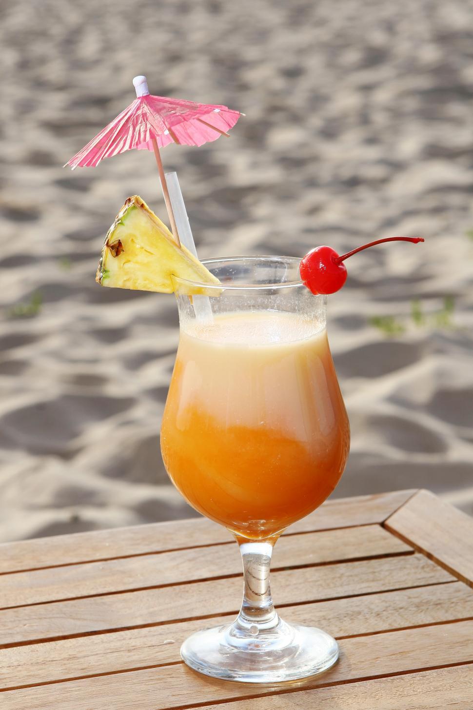 Free Image of sweet fruit cocktail on beach side table 