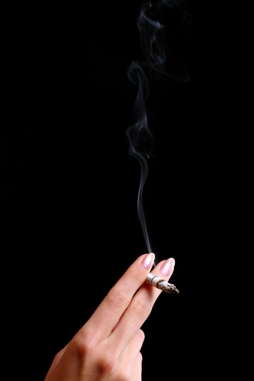 Free Image of Womans hand with a smoking cigarette  